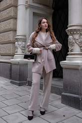 a lady in a mauve wrap coat and a pair of mauve knit pants